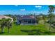 Home showcasing a screened-in pool area, backyard lawn, and landscaping in a serene neighborhood setting at 1167 Boundary Blvd, Rotonda West, FL 33947