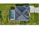 An aerial view of the home highlighting the roof, driveway, and screened-in pool at 1167 Boundary Blvd, Rotonda West, FL 33947