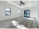 Spacious primary bedroom featuring tray ceiling, a ceiling fan, and sliding glass doors to the lanai at 1167 Boundary Blvd, Rotonda West, FL 33947