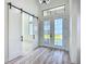 Bright foyer with barn door, stylish lighting, and glass front doors at 1167 Boundary Blvd, Rotonda West, FL 33947