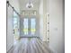 Elegant foyer with high ceilings, barn door, white-framed glass doors, and light wood-look flooring at 1167 Boundary Blvd, Rotonda West, FL 33947