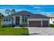 Stunning single-story home featuring a three-car garage, paved driveway, and beautifully landscaped front yard at 1167 Boundary Blvd, Rotonda West, FL 33947