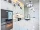 Bright kitchen showcasing white cabinetry, stone countertops, statement lighting, and stainless steel smart refrigerator at 1167 Boundary Blvd, Rotonda West, FL 33947