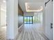 Wide open living space with accent wall, light floors, and glass doors that lead to the pool at 1167 Boundary Blvd, Rotonda West, FL 33947