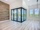 Open concept living area with hardwood-style flooring, decorative wood wall, and sliding glass doors to the lanai at 1167 Boundary Blvd, Rotonda West, FL 33947