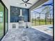 An outdoor kitchen on a screened patio with a stainless steel BBQ and bar fridge at 1167 Boundary Blvd, Rotonda West, FL 33947