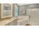 Bathroom featuring tub with tile surround, glass enclosed shower, and double vanity with granite countertop at 13220 Swiftwater Way, Lakewood Ranch, FL 34211