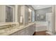 Bathroom with double vanity, granite countertop, bathtub, and a separate glass-enclosed shower at 13220 Swiftwater Way, Lakewood Ranch, FL 34211
