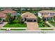 Beautiful tile roof home with a brick driveway, two car garage, and manicured green lawn with palm trees at 13220 Swiftwater Way, Lakewood Ranch, FL 34211