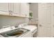 Well-organized laundry room with modern washer, dryer, cabinets, and sink at 13220 Swiftwater Way, Lakewood Ranch, FL 34211