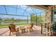 Outdoor patio with a fire pit, bar seating, a lake view, and a stone accent wall at 13220 Swiftwater Way, Lakewood Ranch, FL 34211