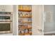 Walk-in pantry with wood shelving and stainless steel KitchenAid oven at 13220 Swiftwater Way, Lakewood Ranch, FL 34211