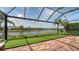 Screened in patio with artificial putting green overlooking a lake, tile floor, and wrought iron frame at 13220 Swiftwater Way, Lakewood Ranch, FL 34211