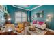 A stylish sitting room with textured blue walls, modern lighting, and eclectic furniture at 13220 Swiftwater Way, Lakewood Ranch, FL 34211