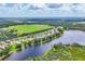 Aerial view of lakefront homes in a neighborhood with lush landscaping and mature trees at 13503 22Nd E Ct, Parrish, FL 34219