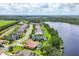 An aerial view showing a residential community along a lake with lush greenery and well-maintained homes and lawns at 13503 22Nd E Ct, Parrish, FL 34219