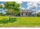 Screened in lanai and sprawling backyard with lush green grass and mature landscaping at 13503 22Nd E Ct, Parrish, FL 34219