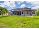 Wide backyard with screened in lanai, covered patio and lush green lawn at 13503 22Nd E Ct, Parrish, FL 34219