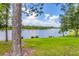 Lush backyard with mature trees and landscaping overlooking tranquil lake views at 13503 22Nd E Ct, Parrish, FL 34219