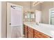 Vanity in bath with white countertop, cherry cabinets, large mirror, and tile flooring at 13503 22Nd E Ct, Parrish, FL 34219