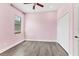 Pink bedroom featuring wood flooring, a window, and a double door closet at 13503 22Nd E Ct, Parrish, FL 34219