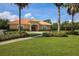 Community clubhouse with a beautiful lawn and landscaped entryway at 13503 22Nd E Ct, Parrish, FL 34219