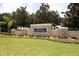 Well-maintained community entrance featuring stone pillars and colorful flowerbeds in River Plantation at 13503 22Nd E Ct, Parrish, FL 34219