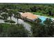Aerial view of community pool and clubhouse, surrounded by lush landscaping and palm trees at 13503 22Nd E Ct, Parrish, FL 34219