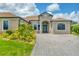 Inviting front exterior showcasing a brick-paved driveway and well-maintained lawn with lush landscaping at 13503 22Nd E Ct, Parrish, FL 34219