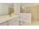 Bright bathroom with a white vanity, toilet, and a frameless glass shower with beige tiling at 1375 Backspin Dr, Englewood, FL 34223