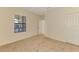 Bright bedroom with carpet, white walls, and a window, with a doorway to the hallway or bathroom at 1375 Backspin Dr, Englewood, FL 34223