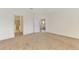 View of the living room and bathroom from a bright empty bedroom with neutral carpet and white walls at 1375 Backspin Dr, Englewood, FL 34223