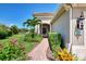 Inviting front entrance with a brick walkway and colorful flowering plants at 1375 Backspin Dr, Englewood, FL 34223