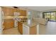 Gourmet kitchen adjacent to a living room and patio, complete with granite countertops and modern appliances at 1375 Backspin Dr, Englewood, FL 34223
