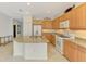 Spacious kitchen with a granite-topped island, white appliances, and light wood cabinets, offering functionality at 1375 Backspin Dr, Englewood, FL 34223
