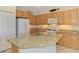 Kitchen island featuring granite countertops, stainless steel sink, and ample space for food preparation at 1375 Backspin Dr, Englewood, FL 34223
