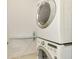 Laundry room with a stacked white washer and dryer and ironing board at 1375 Backspin Dr, Englewood, FL 34223