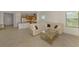 Bright living room features a large beige couch, glass coffee table, and an open floor plan with kitchen access at 1375 Backspin Dr, Englewood, FL 34223