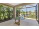The covered patio features a decorative table and relaxing views of the lake at 1375 Backspin Dr, Englewood, FL 34223