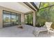 Enjoy the outdoors on this patio featuring a glass-top table and screened-in lanai overlooking lush greenery at 1375 Backspin Dr, Englewood, FL 34223