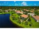 An aerial view showcases a stunning lakefront property surrounded by mature trees and well-manicured lawns at 14714 5Th Ne Ter, Bradenton, FL 34212