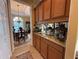 Butler's pantry features granite countertops and wood cabinetry leading into formal dining room at 14714 5Th Ne Ter, Bradenton, FL 34212