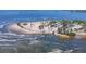 Aerial view of a sandy beach area with palm trees, people, and water activities at 1500 Sunset Rd # B4, Tarpon Springs, FL 34689