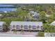 An aerial view of the condo complex shows a beautiful community surrounded by lush trees and other neighborhood homes at 1500 Sunset Rd # B4, Tarpon Springs, FL 34689