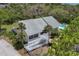 Aerial view of bright, cheerful yellow home with multiple decks, pool, and tropical landscaping at 1500 Sunset Rd # B4, Tarpon Springs, FL 34689