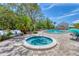 Community spa and pool with brick patio and verdant greenery at 1500 Sunset Rd # B4, Tarpon Springs, FL 34689