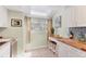 Bright kitchen with butcher block countertops, white cabinets, skylight and breakfast nook seating at 1500 Sunset Rd # B4, Tarpon Springs, FL 34689