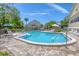 Community outdoor pool with lounge chairs surrounded by lush greenery at 1500 Sunset Rd # B4, Tarpon Springs, FL 34689