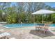 Inviting community pool surrounded by lush landscaping and a patio with seating for relaxation at 1500 Sunset Rd # B4, Tarpon Springs, FL 34689
