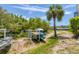 Picturesque yard with palm trees, lush greenery, and storage for kayaks and paddleboards at 1500 Sunset Rd # B4, Tarpon Springs, FL 34689